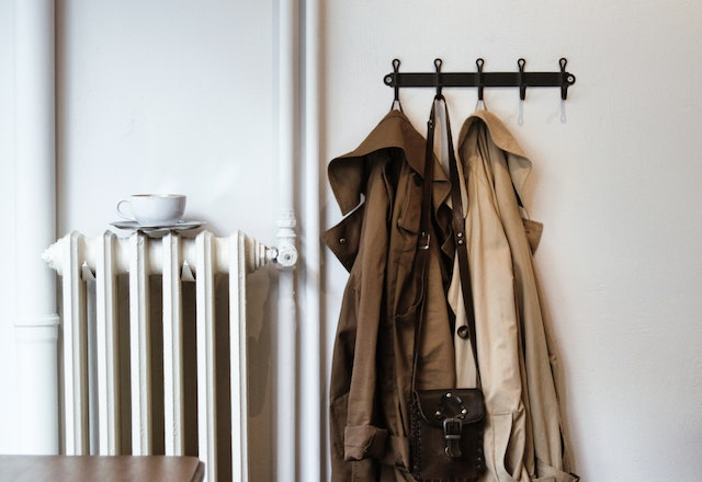 a radiator next to a coat rack